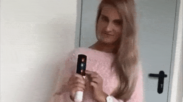 este gif mostra uma mulher loira de blusa rosa claro escovando seus cabelos